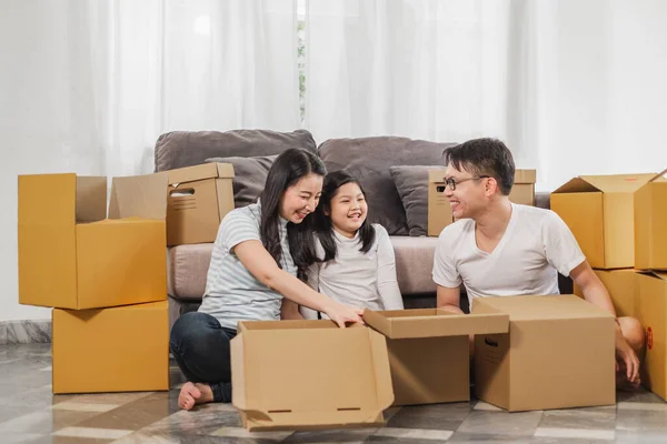 Asyalı aile yeni ev / eve taşınıyor ve kutuları açıyor