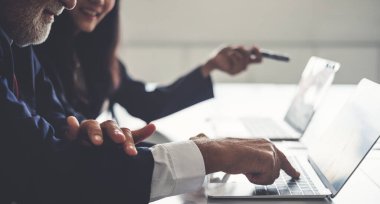 Ofiste ekiple görüşürken bilgisayar kullanan iş adamı elini kapat.