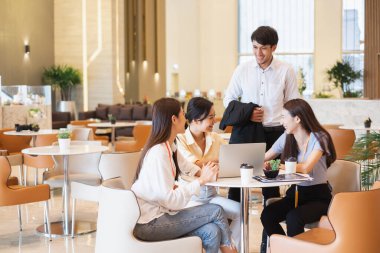 Bir grup Asyalı iş adamı ofiste toplanıyor.