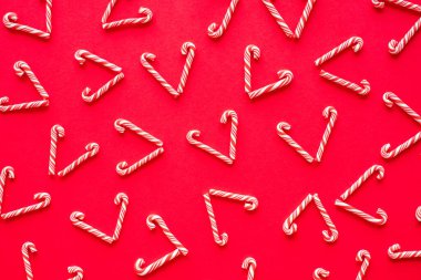 Kırmızı arka planda kalp şeklinde şeker kamışı mutlu yıllar ve sevgililer günü konsepti. Düz yatay üst görünüm.