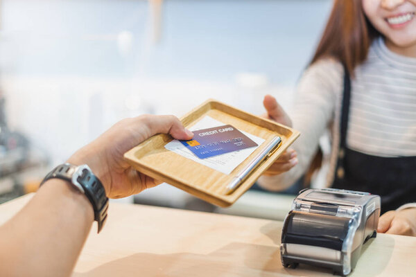 Клиент, использующий кредитную корзину для оплаты владельцу в кафе ресторан, безналичная технология и концепция оплаты кредитной карты
