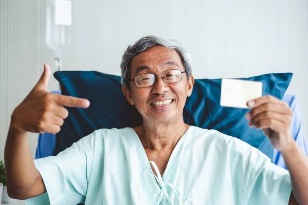 Старий Азіатський Пацієнт Показує Кредитну Картку Щасливою Посмішкою Ліжку Пацієнта — стокове фото