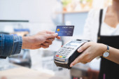 Vásárló hitelkártyával fizet a tulajdonos a kávézó étterem, készpénz nélküli technológia és a hitelkártya fizetési koncepció