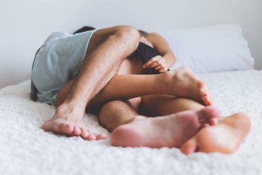 Mutlu çift yatakta, romantik zamanda sarılıp öpüşüyor, aşk ve tutkulu seks kavramı.