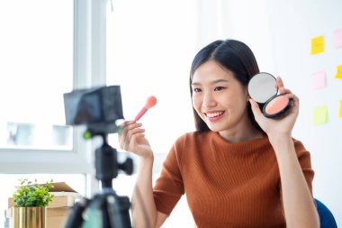 Asyalı kadın güzellik blogcusu / vlog yazarı makyaj malzemesi için öğretiyor