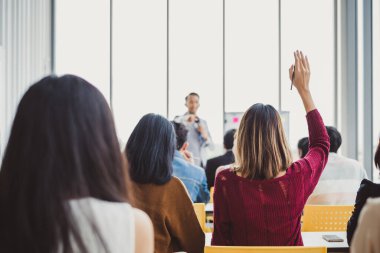 İş kadını, seminer için toplantı odasında soru-cevap konseptini sorduğu için elini kaldırıyor.