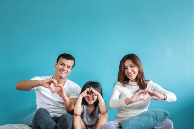 Mavi arka planda mutlu Asyalı aile portresi