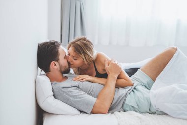 Mutlu çift yatakta, romantik zamanda sarılıp öpüşüyor, aşk ve tutkulu bir konsept..