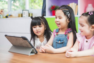 Sınıfta ders almak için tabletten izleyen bir grup tatlı çocuk, eğitim kavramı.