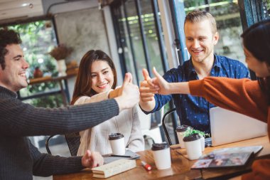 Bir grup genç iş adamı kahve kafesinde tartışıp gülüyorlar.