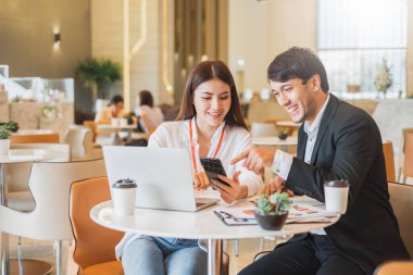 Genç Asyalı iş adamları ve pazarlamacı, çalışma ofislerindeki sigorta ve finansal yatırım planlarını tartışıyorlar.