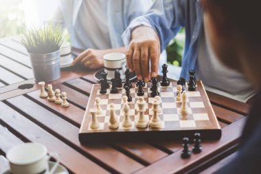 Strateji ve planlama konsepti için satranç tahtasında satranç oynayan kıdemli yaşlı adam.