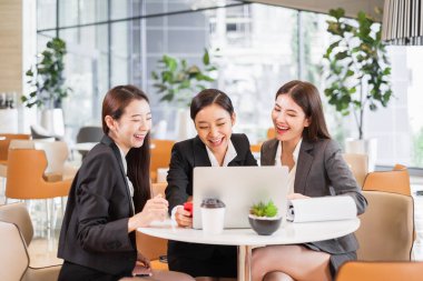 Laptop Mornitor 'a bakan bir grup Asyalı ofiste mutlu ve başarılı.