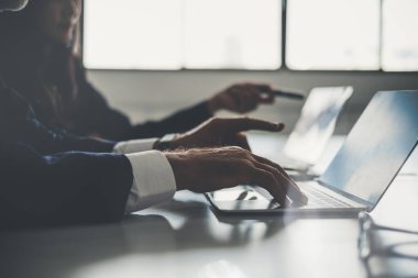 Ofiste ekiple görüşürken bilgisayar kullanan iş adamı elini kapat.