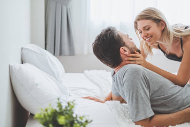 Mutlu çift yatakta, romantik zamanda sarılıp öpüşüyor, aşk ve tutkulu bir konsept..