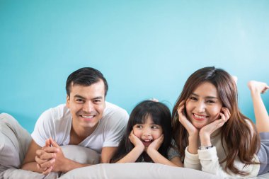 Mavi arka planda mutlu Asyalı aile portresi