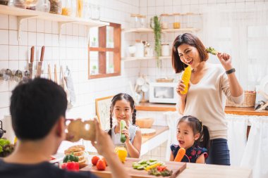 Asyalı aile evde yemek ve oyun oynamayı sever.