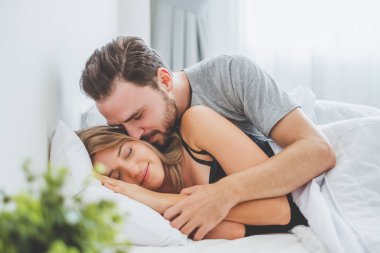 Mutlu çift yatakta, romantik zamanda sarılıp öpüşüyor, aşk ve tutkulu bir konsept..