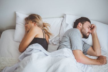 Erkek ve kadın, beyaz yatakta uyuyan çift.
