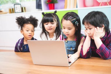 Bir grup öğrenci sınıfta öğrenmek için dizüstü bilgisayar kullanıyor, çocukların eğitim konsepti