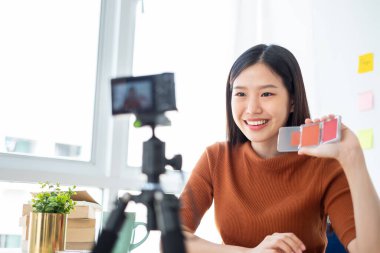 Asyalı kadın güzellik blogcusu / vlog yazarı makyaj malzemesi için öğretiyor