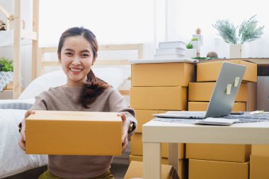 Genç Asyalı kadın satıcı çevrimiçi iş, online alışveriş, nakliyat, konsept için kutu paketi gösteriyor.