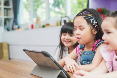 Sınıfta ders almak için tabletten izleyen bir grup tatlı çocuk, eğitim kavramı.