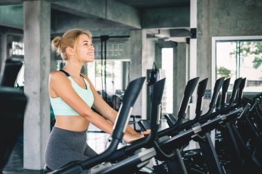 Spor salonunda kardiyo için bisiklet ve spor konseptiyle kadın antrenmanı.