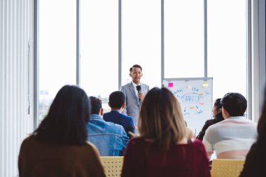 Seminerde konuşmacı, başarı anahtarı için iş toplantısı için birçok seyirciyle konuşuyor.