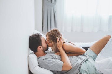 Mutlu çift yatakta, romantik zamanda sarılıp öpüşüyor, aşk ve tutkulu bir konsept..