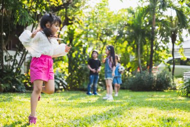 Oyun bahçesinde oynayan ve koşan bir grup çocuk.