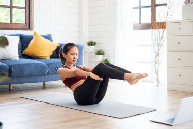 Genç Asyalı sağlıklı kadın antrenmanı evde, egzersiz, formda, yoga yapıyor, spor yapıyor.