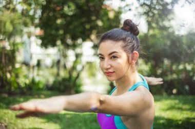 Kadın yoga pozu veriyor / meditasyon yapıyor açık yeşil parkta / bahçede Sabah mutlu bir şekilde