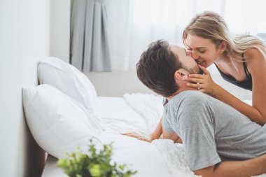 Mutlu çift yatakta, romantik zamanda sarılıp öpüşüyor, aşk ve tutkulu bir konsept..