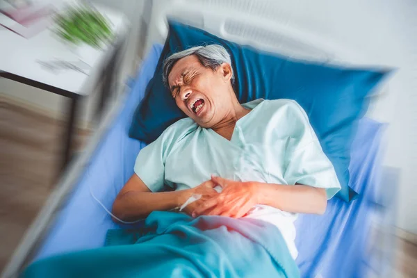 胃の痛みに苦しんでいる古いアジアの患者 痛みを伴う病院の患者ベッドの上に横たわる — ストック写真