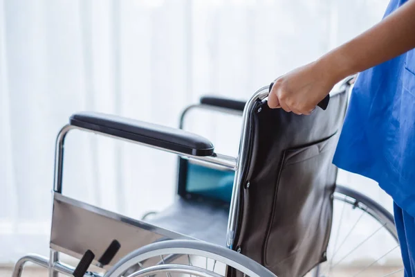 近距离医生 护士手牵手 推推轮椅 推广病人及医疗概念 — 图库照片
