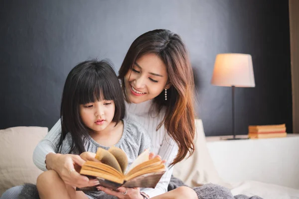 Mutlu Asyalı aile anne ve kızı yataklarında uyumadan önce iyi geceler dileyin.