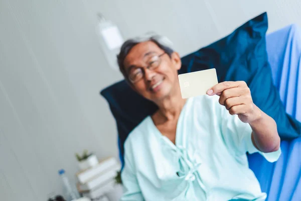 古いですアジアの患者男ショークレジットカードで幸せと笑顔オン患者ベッド — ストック写真