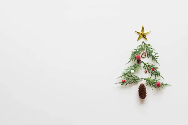 Beyaz arka plan ve fotokopi alanındaki Noel süslerinden yapılmış Noel ağacı. Düz çizgi