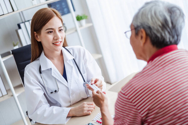 Asian doctor woman explaining old patient for taking medicine, asian medical concept