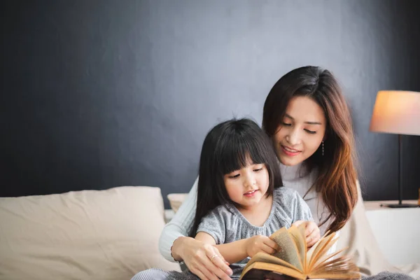 Mutlu Asyalı aile anne ve kızı yataklarında uyumadan önce iyi geceler dileyin.