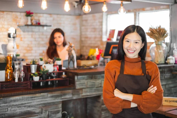 Young asian woman business owner at front of cafe/bar/restaurant/coffee and bakery shop