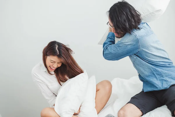 若いですアジアのカップル恋人遊び枕戦い上の白いベッド アジアのカップル恋人のためにバレンタインコンセプト — ストック写真