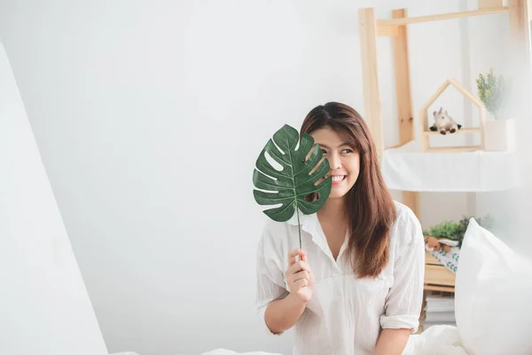 ベッドルームで緑の葉と肖像画の美しいアジアの女性のライフスタイル — ストック写真