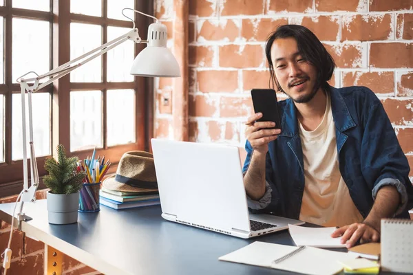 Joven Hombre Asiático Usando Teléfono Trabajando Ordenador Portátil Para Diseñador —  Fotos de Stock