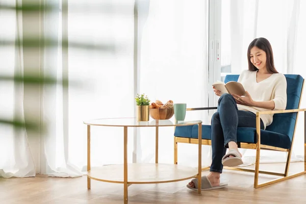 Junge Schöne Asiatin Entspannt Sich Hause Wohnzimmer Liest Bücher Trinkt — Stockfoto