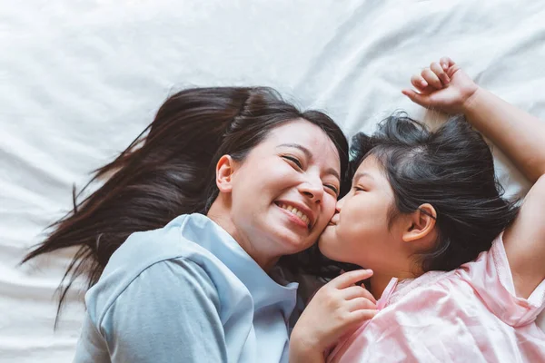 亚洲母亲在卧室亲吻女儿 带着爱心和温暖的家庭观念 — 图库照片