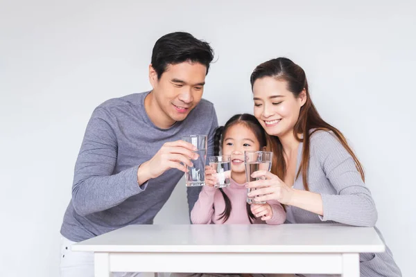 Mutlu Asyalı aile sağlıklı konsept için tatlı su içiyor.
