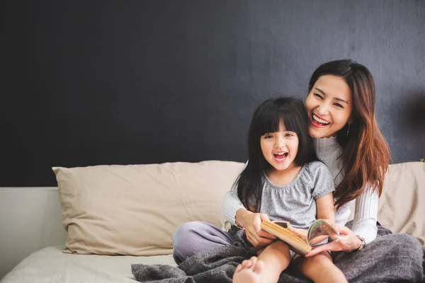 Mutlu Asyalı aile anne ve kızı yataklarında uyumadan önce iyi geceler dileyin.