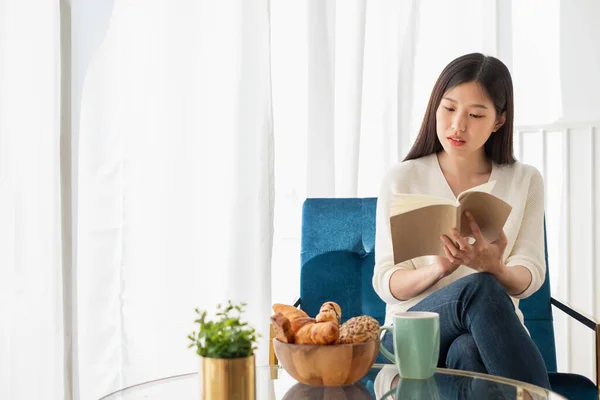 Junge Schöne Asiatin Entspannt Sich Hause Wohnzimmer Liest Bücher Trinkt — Stockfoto